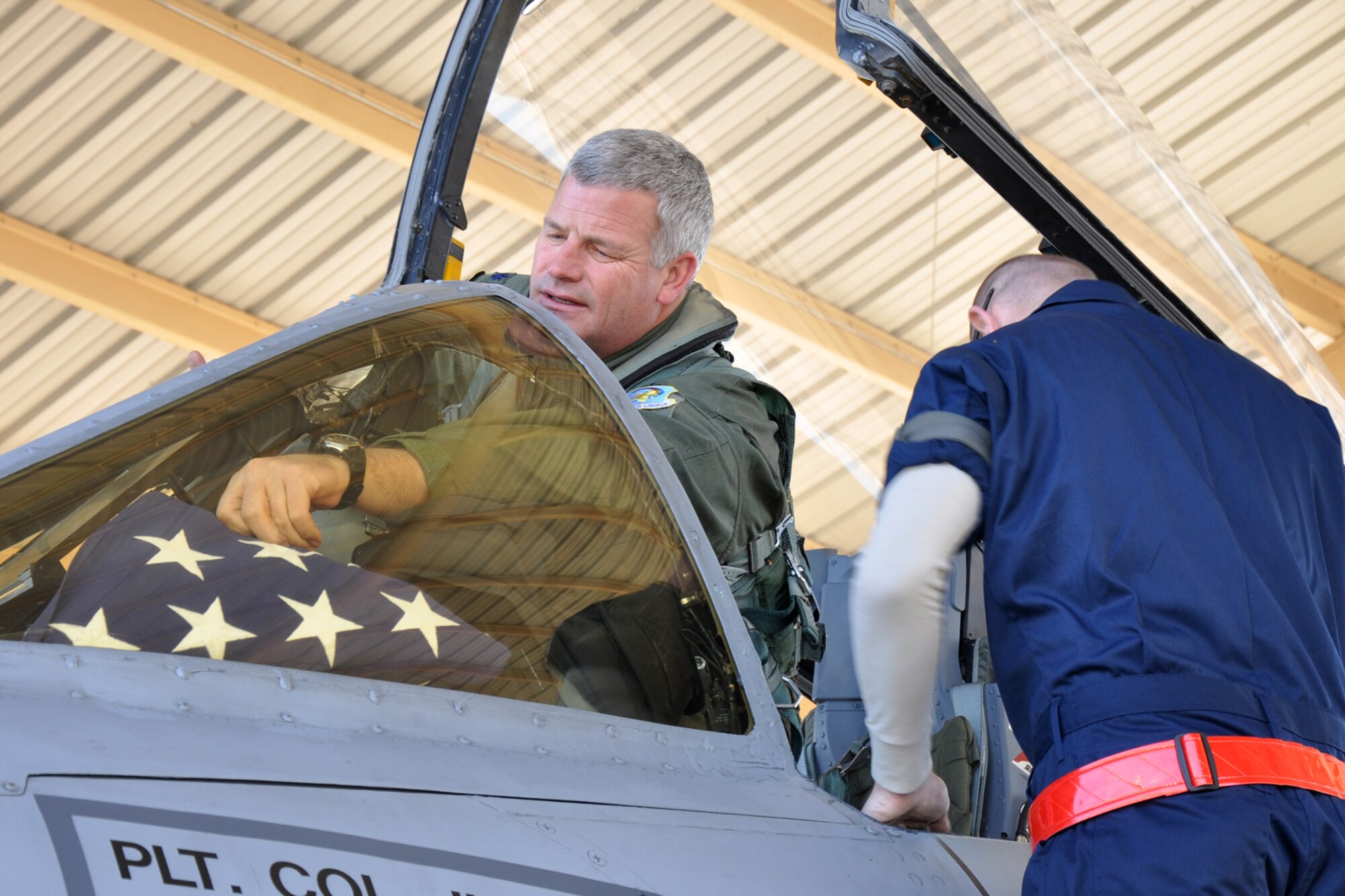Lt. Col. Marc Olson, an A-10 pilot assigned to the 47th Fighter Squadron, stows an American Flag in an A-10 Thunderbolt II before a flight at Barksdale Air Force Base, La., Jan. 11, 2012. Olson carried the burial flag of Retired U.S. Air Force Lt. Col. Ronald L. Hutchison on the sortie. Hutchinson, who was a Bossier City resident, retired at Barksdale in 1978. During his career, Hutchinson flew the F-86, F-100, and the F-4 in Vietnam. (U.S. Air Force photo by Master Sgt. Jeff Walston/Released)