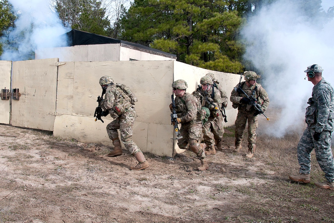 Paratroopers storm a mock compound after using an explosive charge to ...