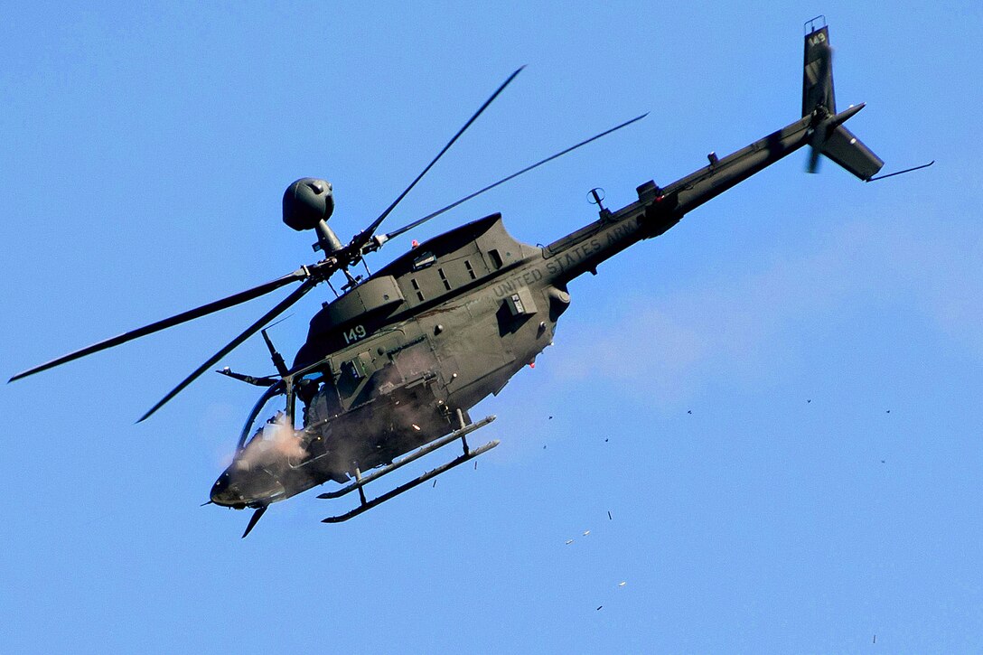 An OH-58 Kiowa helicopter fires its .50 caliber machine gun during a strafing run on a mock enemy compound during a live-fire exercise at the Joint Readiness Training Center on Fort Polk, La., Jan. 14, 2012. 