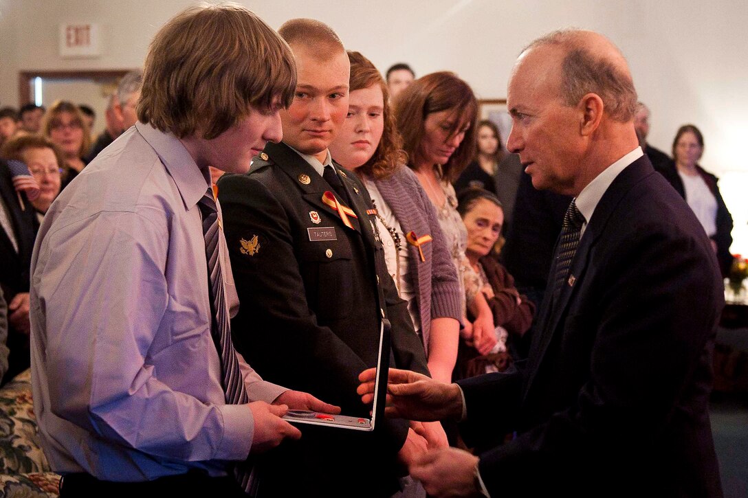 Indiana Gov. Mitch Daniels, right, presents Matthew Tauteris, the son