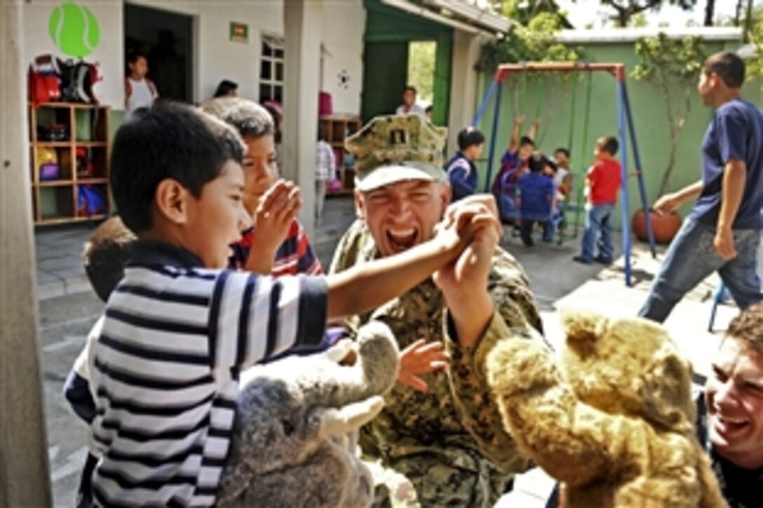 U.S. Navy Lt. Lawrence White distributes stuffed animals to children at San Gaspar Vivar in Antigua, Guatemala, Jan. 12, 2012. White is assigned to the Maritime Civil Affairs Team, aboard High Speed Vessel 2 Swift. The visit was part of Southern Partnership Station 2012, an annual deployment of U.S. ships to the U.S. Southern Command area of responsibility in the Caribbean, Central and South America.