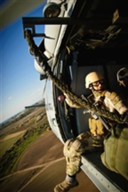 A U.S. Navy sailor rides in an MH-60 Seahawk helicopter from Helicopter Sea Combat Squadron 28 during rope suspension training with Explosive Ordnance Disposal Mobile Unit 8 and EOD Training and Evaluation Unit 2 in Rota, Spain, on Jan. 11, 2012.  