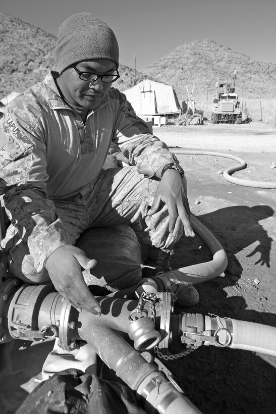 Sgt. Xuchill Laput, a regional fuel farm site manager with Bulk Fuel Platoon, 9th Engineer Support Battalion, 2nd Marine Logistics Group (Forward), points out where fuel is separated into multiple distribution points aboard Forward Operating Base Whitehouse, Afghanistan, Jan. 18. Laput is in charge of managing specifications and regulations at four different sites around Helmand province. (U.S. Marine Corps photo by Cpl. Katherine M. Solano)