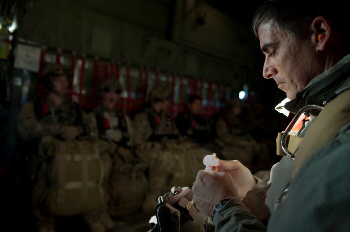 A U.S. Air Force pararescueman, 58th Rescue Squadron, looks over his gear prior to jumping out of a C-130 Hercules, Air National Guard, Long Island, NY, during a military static-line jump Jan. 13, 2012, at Nellis Air Force Base, Nev. Pararescuemen are trained to provide emergency medical treatment in adverse terrain and conditions in combat or peacetime. (U.S. Air Force photo by Staff Sgt. Christopher Hubenthal/Released)
