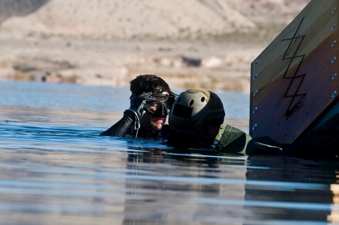 A U.S. Air Force pararescueman, 58th Rescue Squadron, secures his goggles before going underwater to untangle straps from a Rigging, Alternate Method Zodiac during a military freefall water jump Jan. 10, 2012, at Echo Bay, Nev. Pararescuemen are trained to provide emergency medical treatment in adverse terrain and conditions in combat or peacetime. (U.S. Air Force photo by Airman 1st Class Daniel Hughes/Released)
