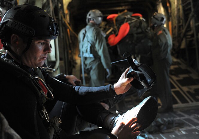 A U.S. Air Force pararescueman, 58th Rescue Squadron, dons his equipment prior to reaching a designated drop zone on a C-130 Hercules, Air National Guard, Long Island, NY, during a military freefall water jump Jan. 10, 2012, over Echo Bay, Nev. Pararescuemen are trained to provide emergency medical treatment in adverse terrain and conditions in combat or peacetime. (U.S. Air Force photo by Staff Sgt. Christopher Hubenthal/Released)


