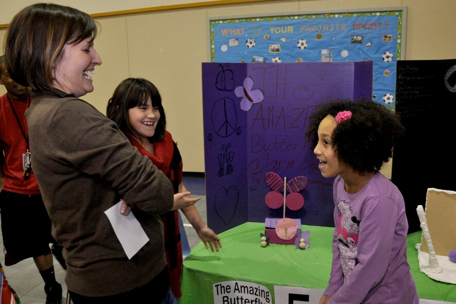 Sarah Schubert, left, the school age coordinator with the Youth Center, Marriannah Perez, center, daughter of 2nd Lt. Michelle Perez, 71st Medical Group, and Lyndsey Lewis, daughter of Master. Sgt. Erik Lewis, 71st Force Support Squadron, share a laugh during Invention Convention competition Jan. 17, at the Youth Center at Vance Air Force Base, Okla. Marriannah and Lyndsey won the Best Design award for their butterfly alarm clock. (U.S. Air Force photo/ Airman 1st Class Frank John Casciotta)