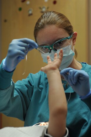 U.S. Air Force Maj. Amy Dyer, 99th Dental Squadron pediatric dentist, teaches Brandon Neece, son of Anthony Neece, retired Master Sgt., the methods of flossing during a dental exam Jan. 17, 2012, at Nellis Air Force Base, Nev. February is Children's Dental Health Month.  During the month, Airmen from the 99th Dental Squadron plan to educate military dependents on proper oral hygiene. They also will volunteer with Las Vegas valley dentists to assist with cleaning, general dentistry and special care for those in need. (U.S. Air Force photo by Staff Sgt. Christopher Hubenthal/Released)