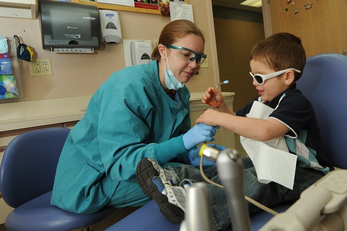 U.S. Air Force Maj. Amy Dyer, 99th Dental Squadron pediatric dentist, shows  Brandon Neece, son of Anthony Neece, retired Master Sgt., how some dental equipment works prior to a dental exam Jan. 17, 2012, at Nellis Air Force Base, Nev. February is Children's Dental Health Month.  During the month, Airmen from the 99th Dental Squadron plan to educate military dependents on proper oral hygiene. They also will volunteer with Las Vegas valley dentists to assist with cleaning, general dentistry and special care for those in need. (U.S. Air Force photo by Staff Sgt. Christopher Hubenthal/Released)
