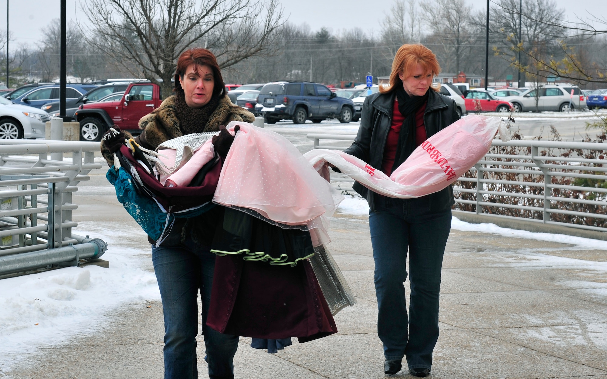 The Scott Enlisted Spouse Club president Sherri Madrigal and Vice President Lagea Mull carry 50 dresses to donate to the Metro St. Louis Cinderella Project Dec. 13, 2012. (U.S. Air Force photo/Staff Sgt. Stephenie Wade)