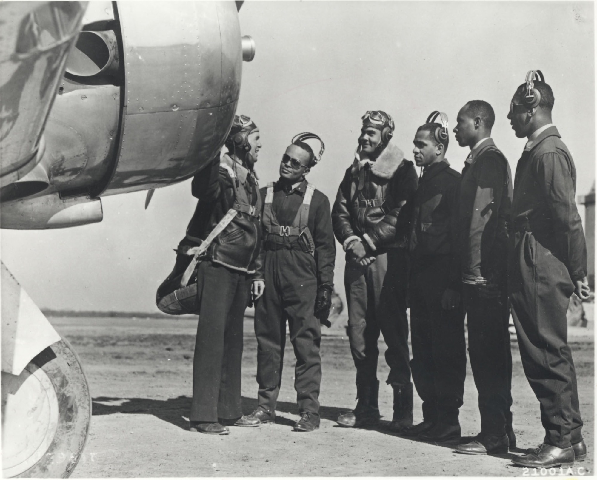 Members of the first pilot class at the advanced flying school at Tuskegee, Alabama, listening to their instructor, 1942.