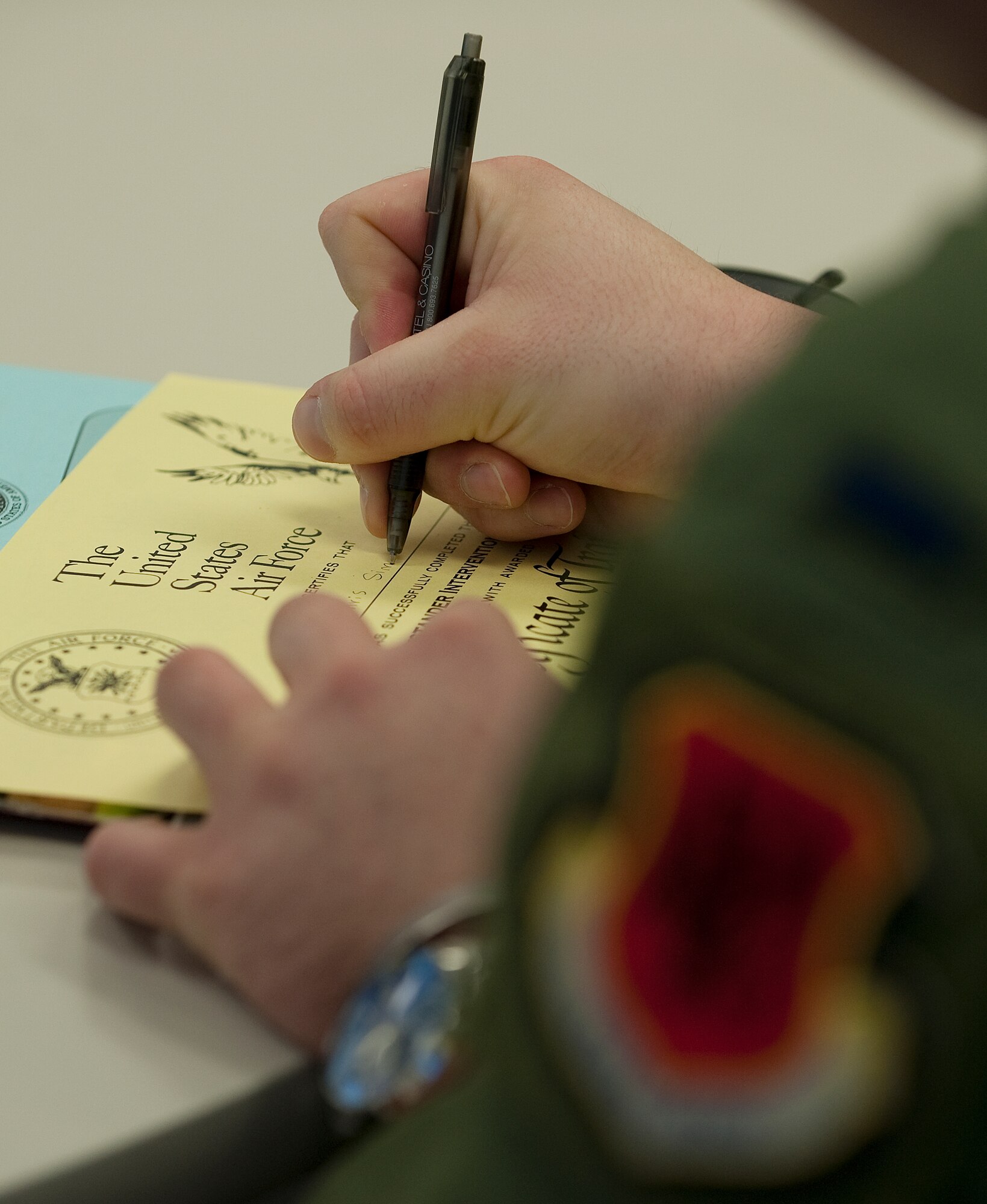 A U.S. Air Force Airman signs his Bystander Intervention Training certificate Jan. 17, 2012, at Nellis Air Force Base, Nev. Airmen are required to complete the BIT course by June 2012. (U.S. Air Force photo by Staff Sgt. Christopher Hubenthal/Released)