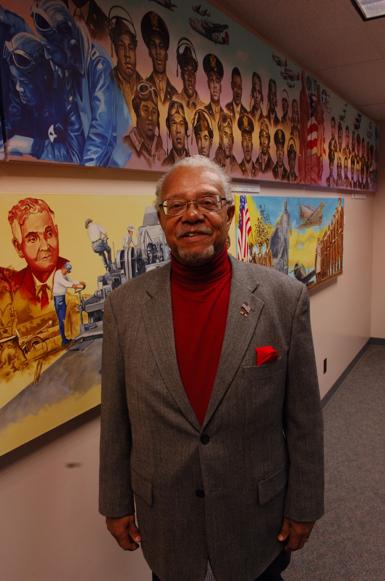 William Curtis, the painter of The Tuskegee Airman paintings, stands in front of his artwork at the base library at Scott Air Force Base, Ill. Jan, 13, 2012. Curtis started painting at the age of four. (U.S. Air Force photo/ Airman 1st Class Jake Eckhardt)
