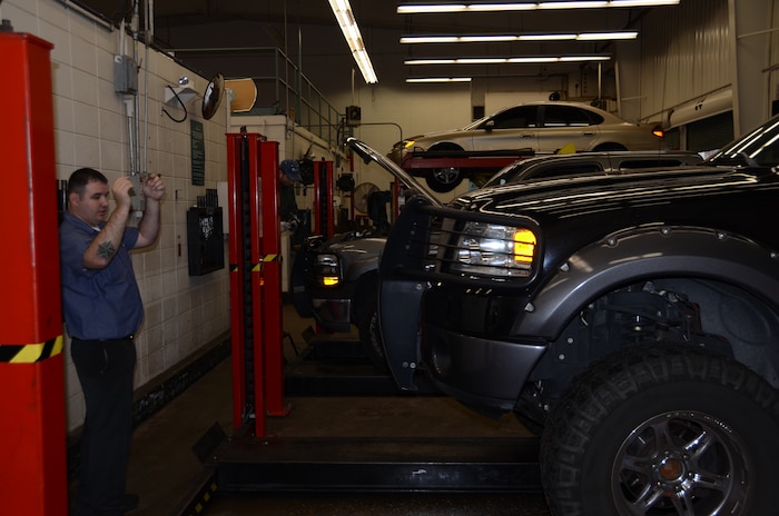 Richard Reinhardt, 628th Force Support Squadron Auto Hobby Shop mechanic, directs a customer onto a vehicle lift Jan. 11 at Joint Base Charleston-Air Base. Qualified mechanics are on staff at the Auto Hobby Shop to assist do-it-yourself customers with car care needs. (U.S. Air Force photo by/Senior Airman Anthony J. Hyatt)
