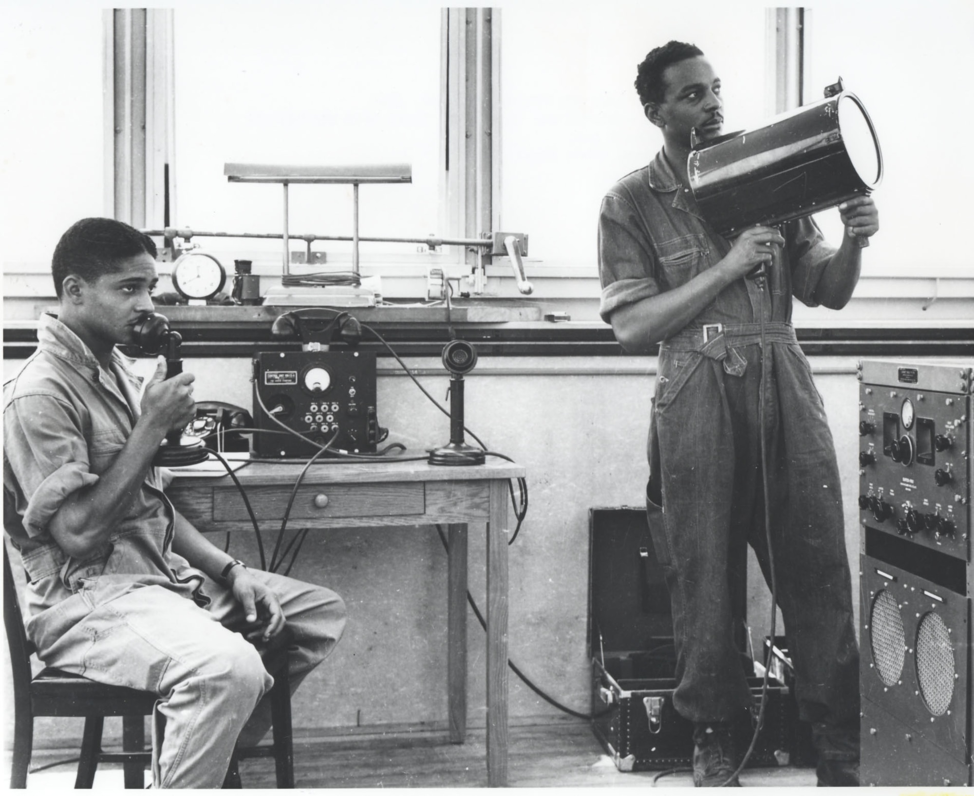 Support staff training in control tower with microphone and biscuit gun, 1942.