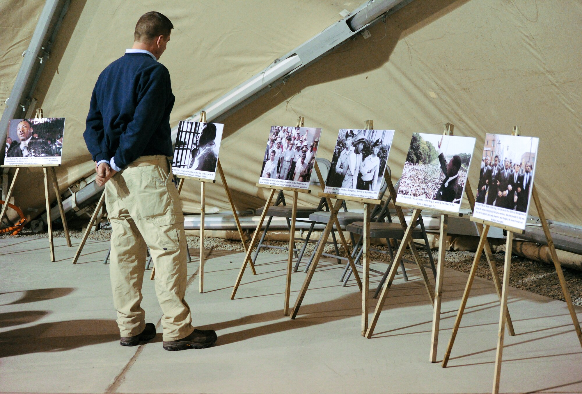 Jeffrey Aulwurm, a U.S. contractor with the 376th Expeditionary Force Support Squadron, views posters highlighting significant events in the life of Dr. Martin Luther King Jr. during a commemorative reception at the Transit Center at Manas, Kyrgyzstan, Jan. 16, 2012. There were 13 posters that were displayed along a walking route and inside the community activities center.(U.S. Air Force photo/Master Sgt. Tracy L. DeMarco)