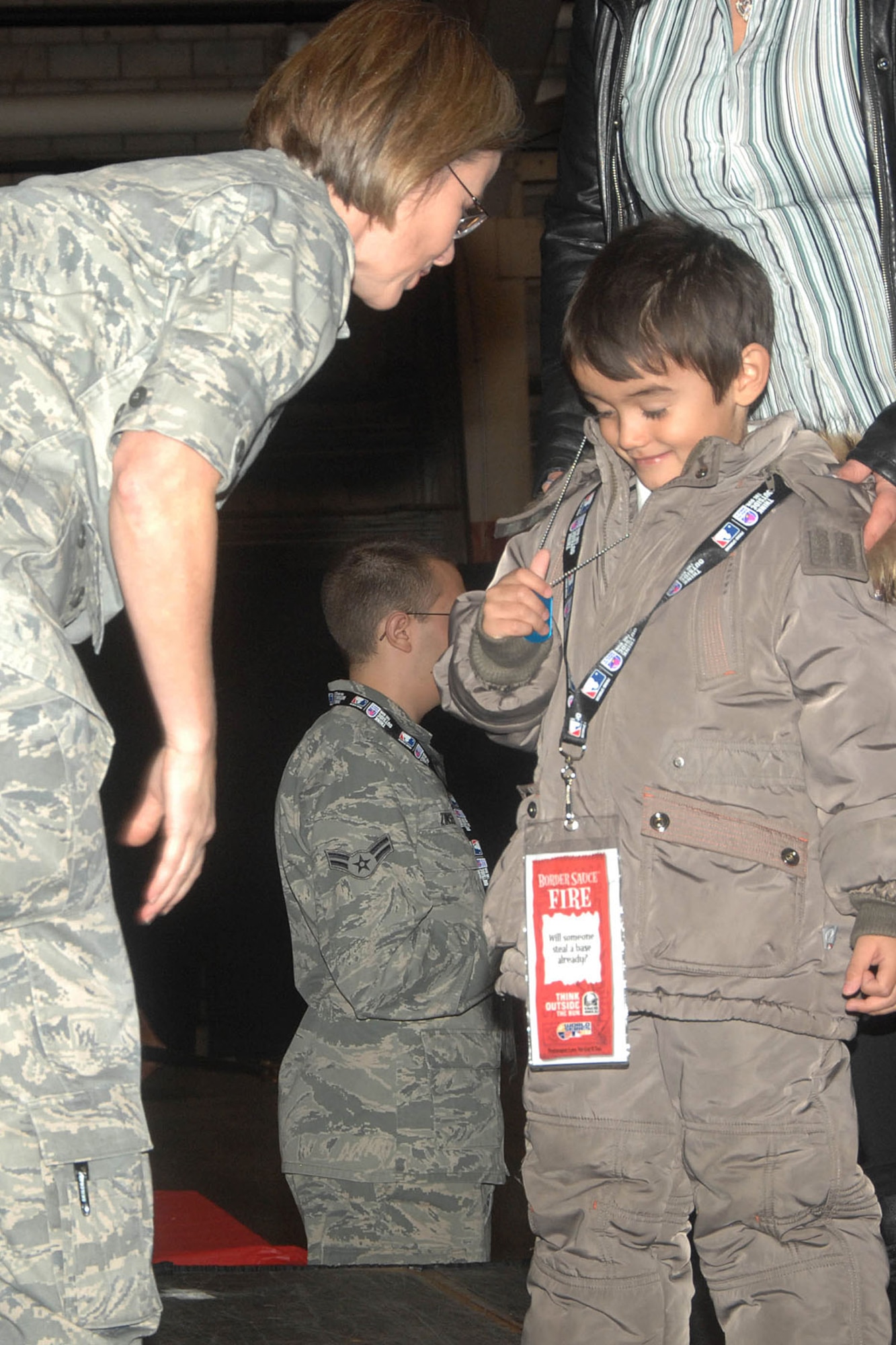 HANSCOM AIR FORCE BASE, Mass. - Col. Stacy L. Yike (left), 66th Air Base Group commander, looks at Victor Thiphavong’s dog tag memento during the Heroes Homecoming ceremony in the Aero Club Hangar Jan. 12. Thiphavong was one of the many family members of returned deployers honored during the celebration. (U.S. Air Force photo by Linda LaBonte Britt)