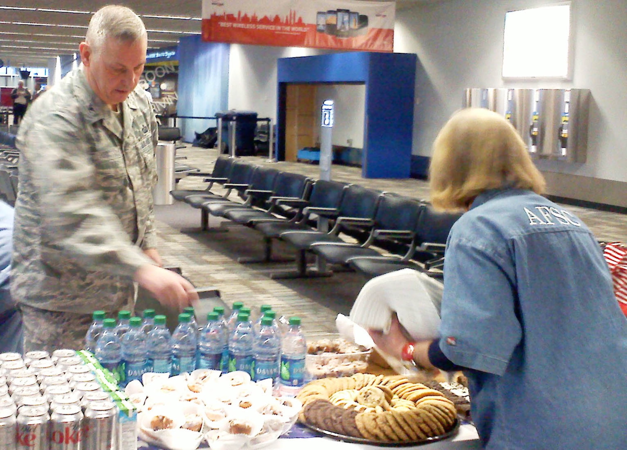 Col. Michael Ochs, 934th Mission Support Group commander, helps an Armed Forces Service Center volunteer set up refreshments for distinguished visitors at the Minneapolis-St. Paul International Airport.  The AFSC at the airport is open to active, guard and reserve members from all service branches. (Air Force photo/Capt. S.J. Brown)