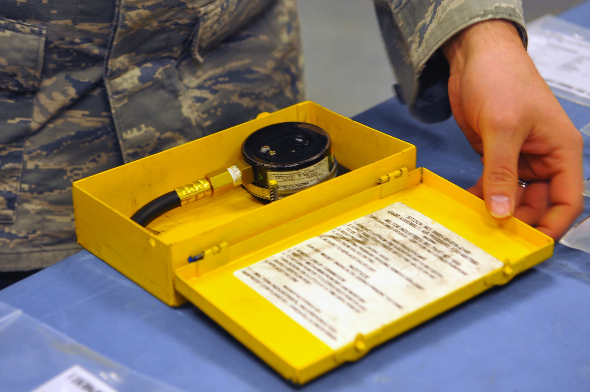 SPANGDAHLEM AIR BASE, Germany – Staff Sgt. Joseph Robinson, 52nd Component Maintenance Squadron electronic warfare craftsman, prepares a hydraulic-line pressure gauge assembly inside the precision measurement equipment laboratory centralized collection point (PMEL CCP) here Jan. 18 for an upcoming delivery. PMEL CCP saves the Air Force money by gathering equipment from 77 separate unit accounts and delivering them to the precision measurement equipment laboratory at Ramstein Air Base in one truckload rather than 77 separate trips. The PMEL CCP delivers unit equipment ranging from a torque wrench to radio frequency signal generators used to calibrate aircraft avionics systems. (U.S. Air Force photo/Airman 1st Class Dillon Davis)