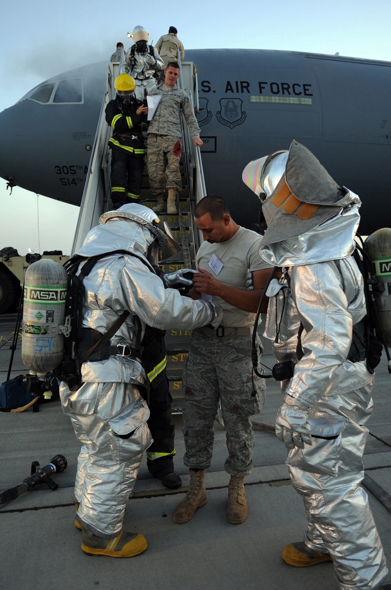 SOUTHWEST ASIA - Firefighters and other first responders evacuate "injured" people from a KC-10 Extender during a major accident response exercise at the 380th Air Expeditionary Wing Jan. 18, 2012. The exercise tested the wing's response capabilities in the event of a plane crash. In addition, members of the host nation air force partnered with the Airmen and Soldiers, ensuring a cohesive response to a real-world emergency. (U.S. Air Force photo/Staff Sgt. J.G. Buzanowski)