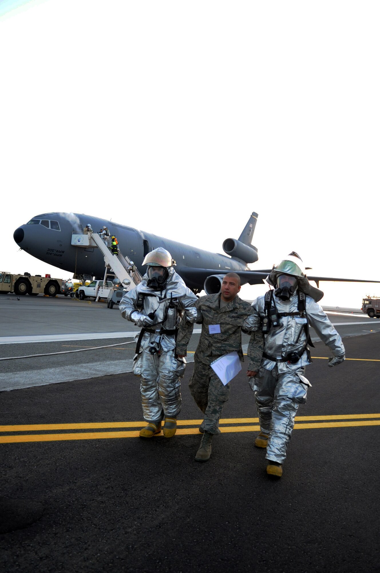 SOUTHWEST ASIA - Firefighters and other first responders evacuate "injured" people from a KC-10 Extender during a major accident response exercise at the 380th Air Expeditionary Wing Jan. 18, 2012. The exercise tested the wing?s response capabilities in the event of a plane crash. In addition, members of the host nation air force partnered with the Airmen and Soldiers, ensuring a cohesive response to a real-world emergency. (U.S. Air Force photo/Staff Sgt. J.G. Buzanowski)
