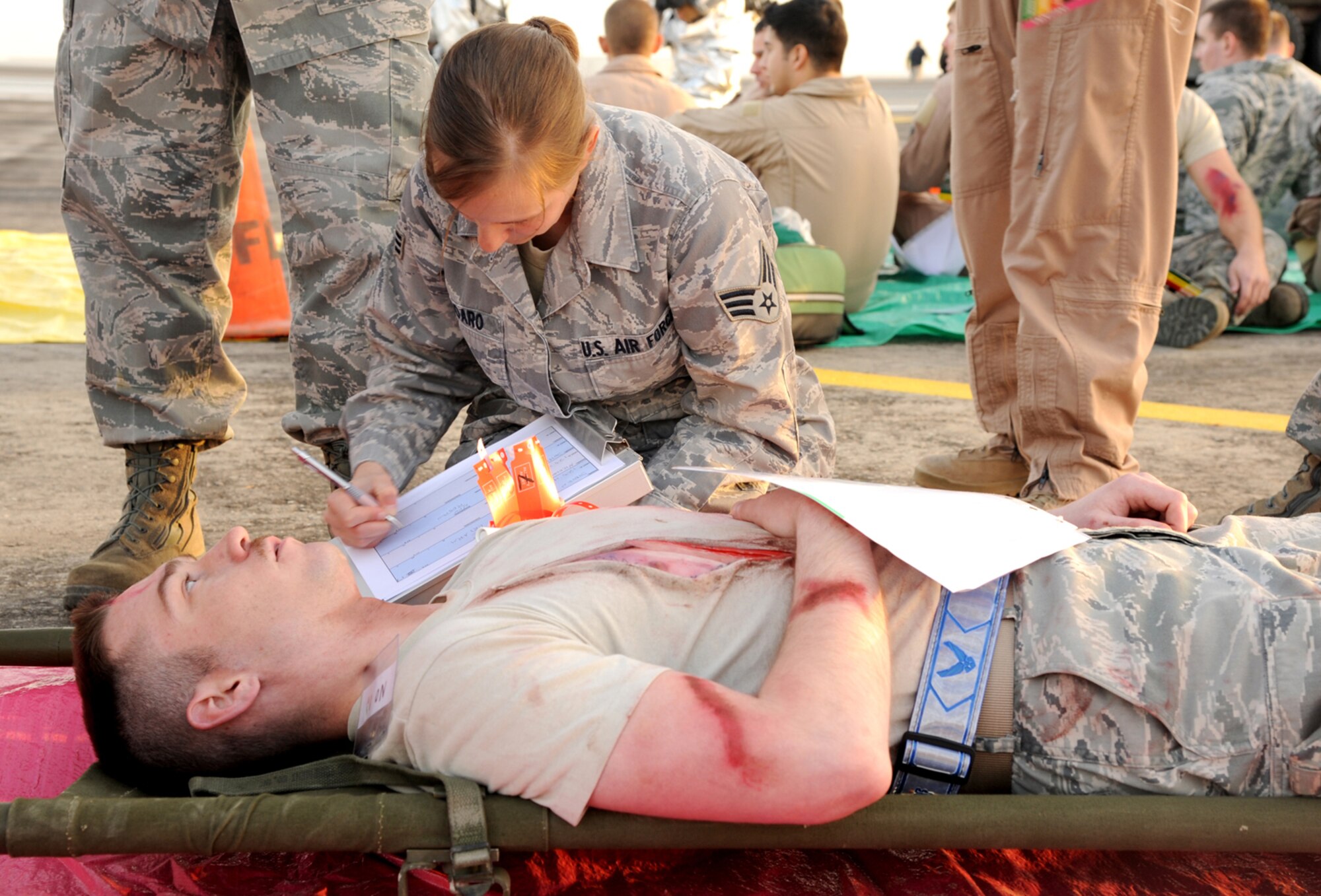 SOUTHWEST ASIA - Senior Airman Stephanie Todaro assesses patient Staff Sgt. Anthony Sullivan at the flightline Jan. 18, 2012.  The 380th Air Expeditionary Wing Airmen participated in a major accident response exercise to keep Airmen prepared in case of a real-world disaster.  Todaro a New Orleans La. native is assigned to the 380th Expeditionary Medical group and Sullivan is assigned to 380th Expeditionary Communication squadron, deployed from Davis Monthan Air Force Base, Ariz. (U.S. Air Force photo/Tech. Sgt. Arian Nead)  