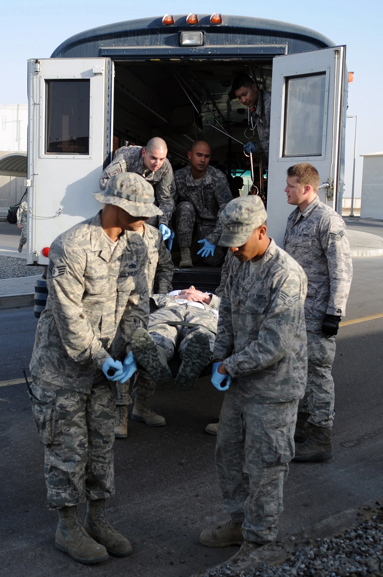 SOUTHWEST ASIA - Airmen and Soldiers assigned to the 380th Air Expeditionary Wing evacuate a patient from an ambulance bus during a major accident response exercise Jan. 18, 2012. The exercise tested the wing?s response capabilities in the event of a plane crash. In addition, members of the host nation air force partnered with the Airmen and Soldiers, ensuring a cohesive response to a real-world emergency. (U.S. Air Force photo/Staff Sgt. J.G. Buzanowski)