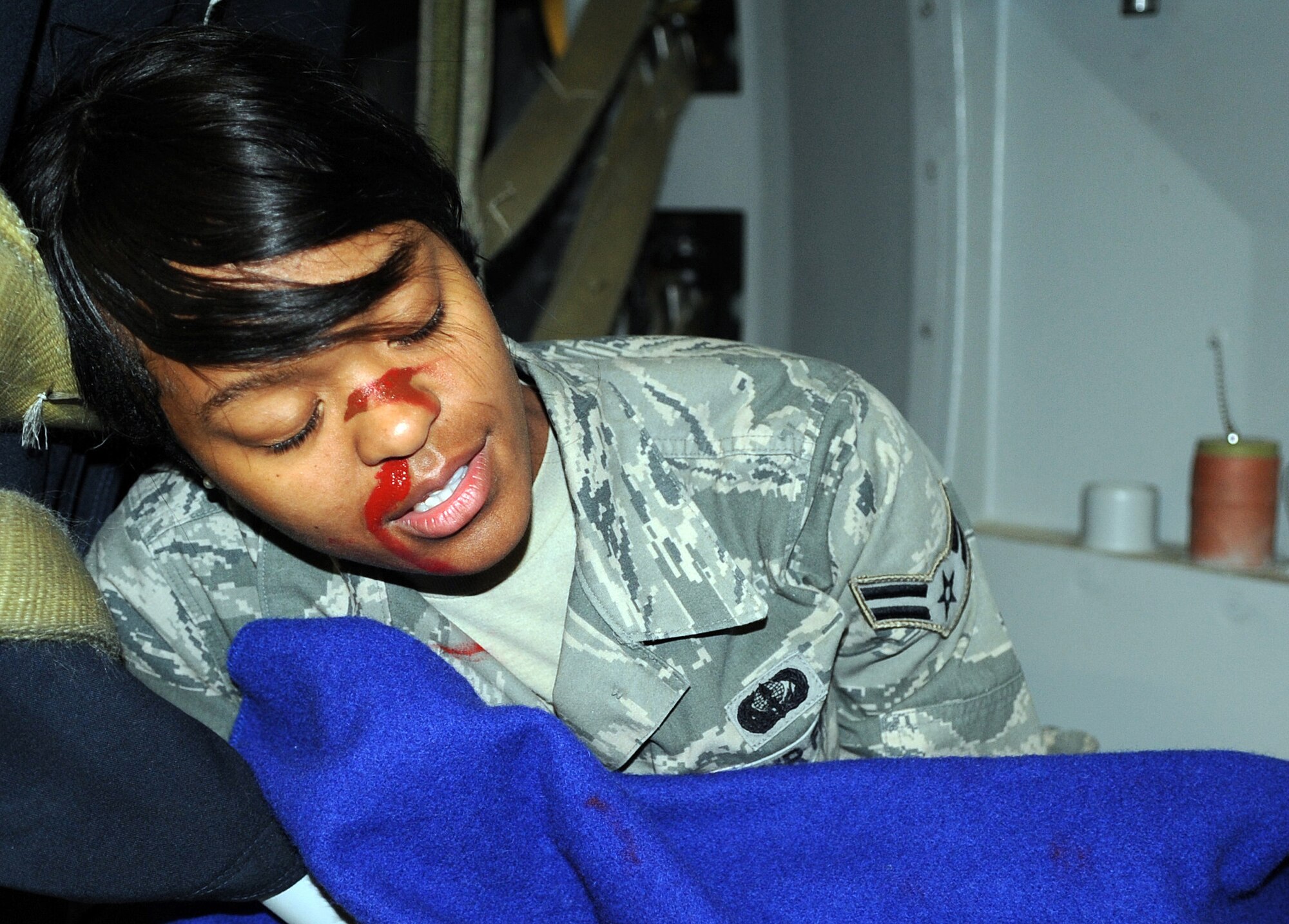 SOUTHWEST ASIA - Airman 1st Class Chermara Cuffee plays an injured passenger aboard a KC-10 Extender during a major accident response exercise at the 380th Air Expeditionary Wing Jan. 18, 2012. The exercise tested the wing?s response capabilities in the event of a plane crash. In addition, members of the host nation air force partnered with the Airmen and Soldiers, ensuring a cohesive response to a real-world emergency. Cuffee is deployed from Joint Base Lewis-McChord, Wash. (U.S. Air Force photo/Staff Sgt. J.G. Buzanowski)