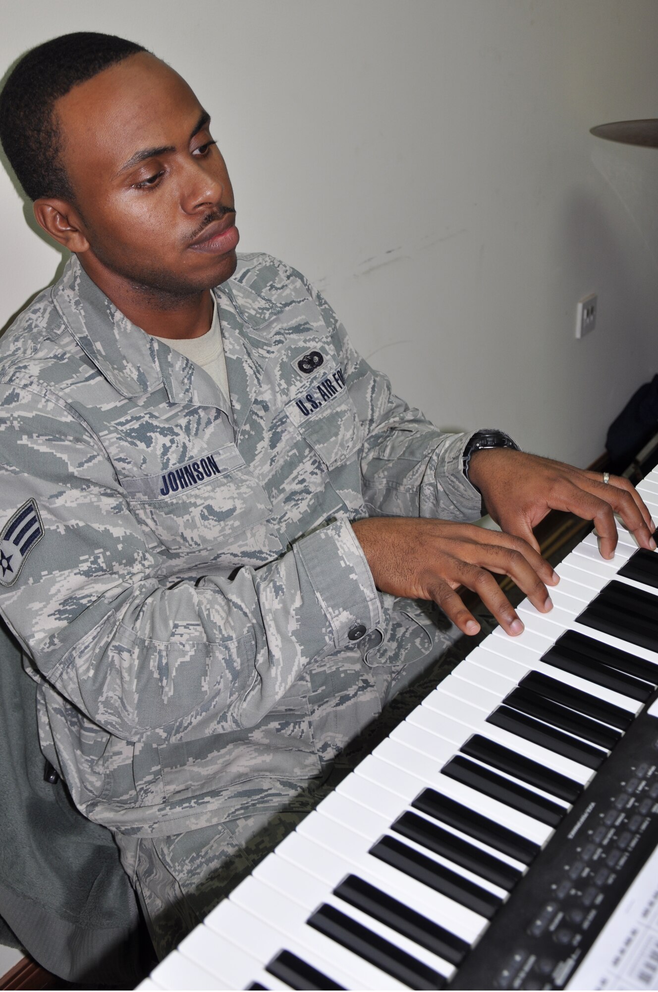 Senior Airman Barrett Johnson, 332nd Expeditionary Security Forces Squadron, plays piano during the Martin Luther King Day celebration in the base chapel at an undisclosed location in Southwest Asia Jan. 16, 2012. Johnson is deployed from Moody Air Force Base, Ga. (photo by Senior Airman Melanie Holochwost)