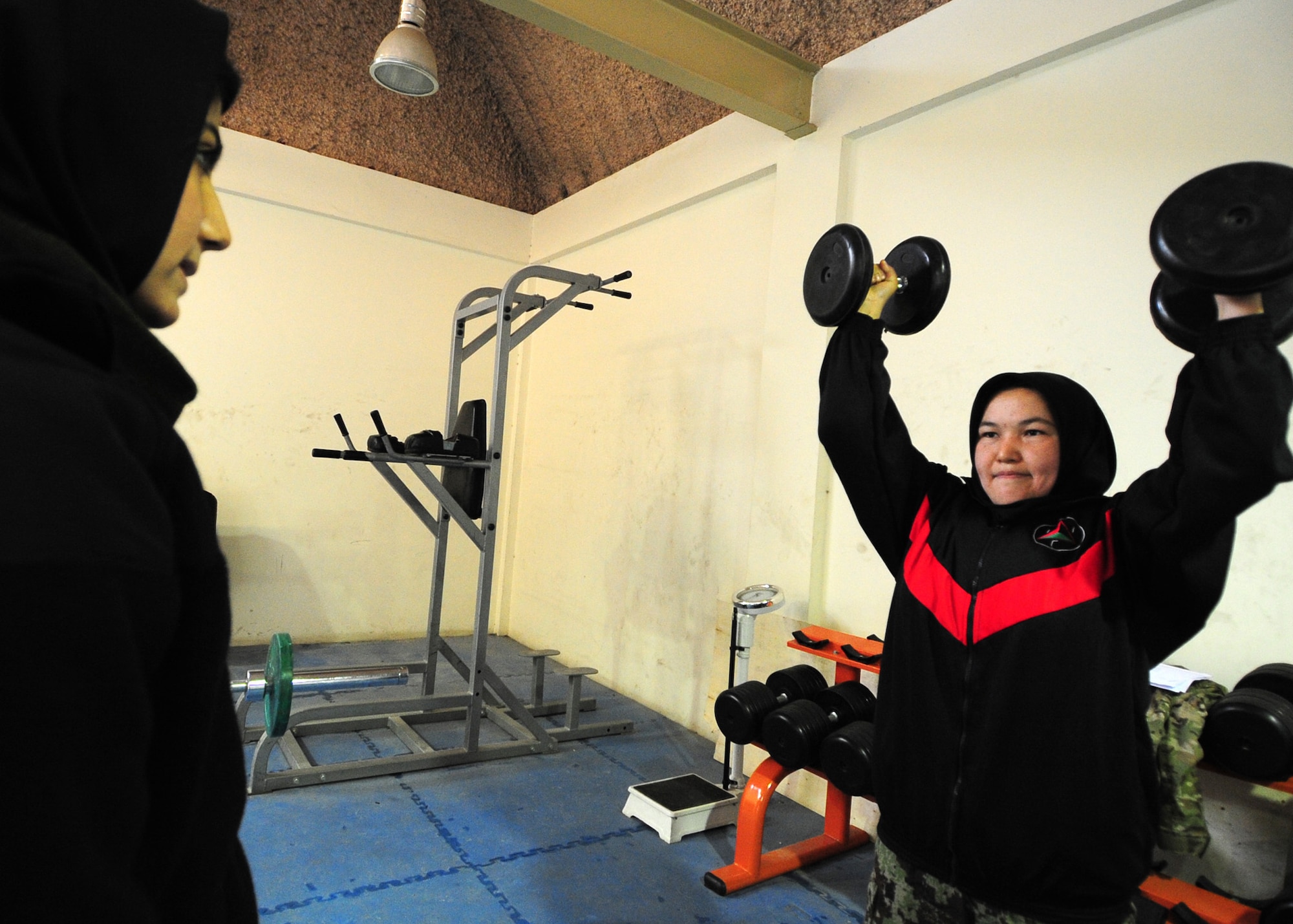 Afghan air force member, Neloofar Rahmani, provides AAF member, Semen Ferozi, with an accurate count for correctly performed exercises during a workout session at Kabul International Airport, Jan. 18, 2012. U.S. Air Force Capt. Vanessa Vanden Bout, a 29-year-old Force Support Squadron advisor with the 439th Air Expeditionary Advisory Squadron from Vermilion, Ohio, initiated the creation of a physical fitness class for women of the AAF, with a focus on learning how to work out properly and safely with an ultimate goal of educating the women about the benefits of a daily workout regimen. (U.S. Air Force photo by Staff Sgt. Nadine Y. Barclay)  