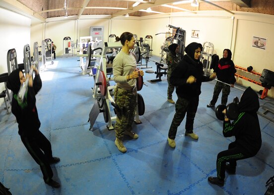 Capt. Vanessa Vanden Bout, a Force Support Squadron advisor with the 439th Air Expeditionary Advisory Squadron, provides over watch support for Afghan air force females during a workout session at Kabul International Airport, Jan. 18, 2012. Vanden Bout, a 29-year-old from Vermilion, Ohio, initiated the creation of a physical fitness class for women of the AAF, with a focus on learning how to work out properly and safely with an ultimate goal of educating the women about the benefits of a daily workout regimen. (U.S. Air Force photo by Staff Sgt. Nadine Y. Barclay)  