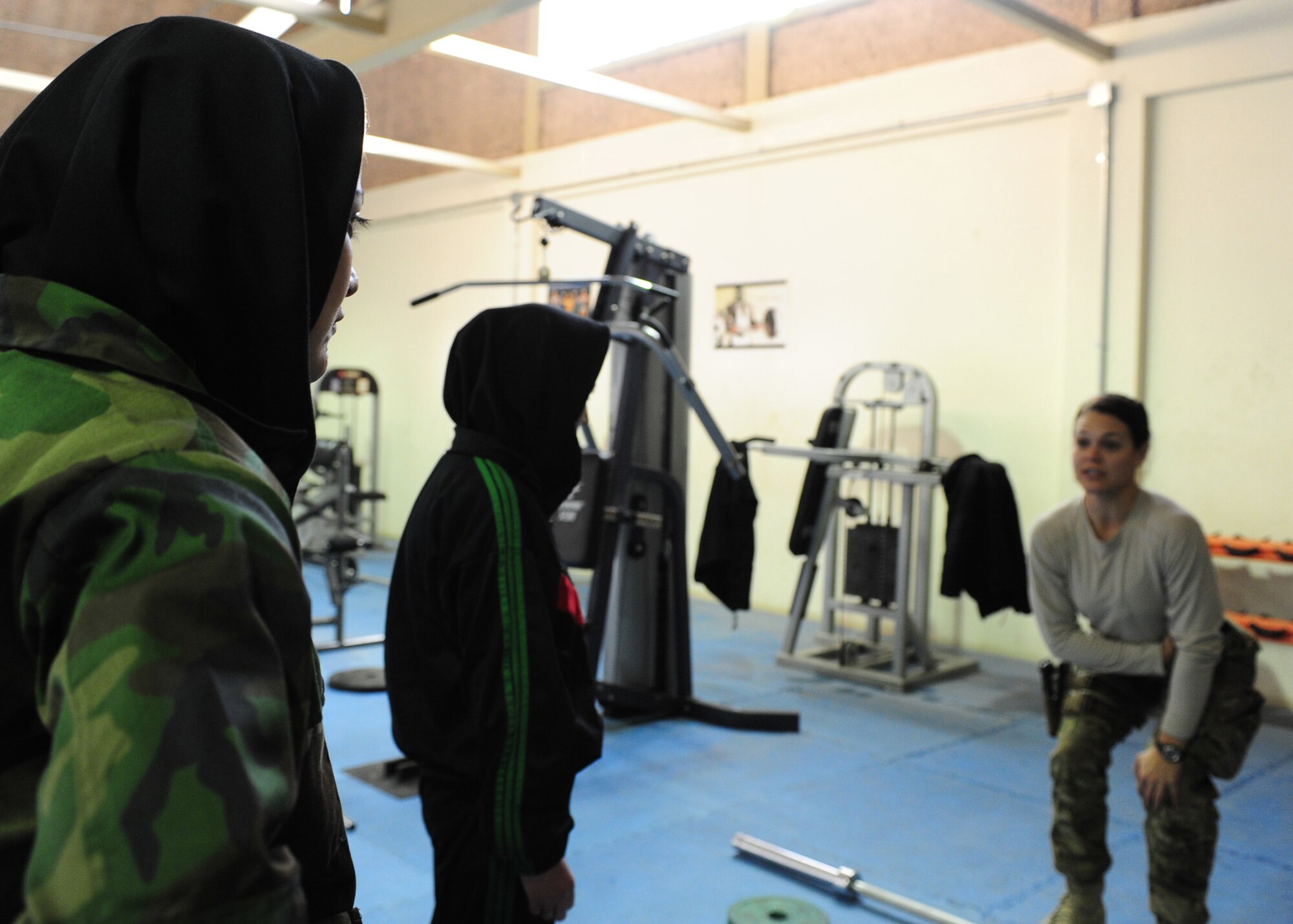 Afghan air force member Fatema Abteen, watches U.S. Air Force Capt. Vanessa Vanden Bout, a Force Support Squadron advisor with the 439th Air Expeditionary Advisory Squadron, demonstrate proper form for a dead-lift exercise during a workout session at Kabul International Airport, Jan. 18, 2012. Vanden Bout, a 29-year-old from Vermilion, Ohio, initiated the creation of a physical fitness class for women of the AAF, with a focus on learning how to work out properly and safely with an ultimate goal of educating the women about the benefits of a daily workout regimen. (U.S. Air Force photo by Staff Sgt. Nadine Y. Barclay)  