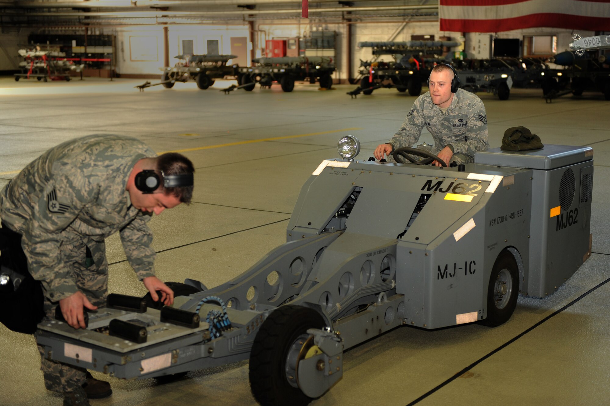 SPANGDAHLEM AIR BASE, Germany – Staff Sgt. Michael Elkington, 81st Aircraft Maintenance Unit weapons load crew chief, prepares an MJ-1 to be driven by Staff Sgt. James Clay, 81st AMU weapons load crew member, during a load crew of the quarter competition in Hanger 1 here Jan. 13. This 81st AMU team competed against a weapons load crew from the 480th AMU and won the competition. The crew will compete in the 2011 Load Crew of the Year competition against the winners from the previous quarterly competitions. The competitions are held to showcase the teamwork and capabilities of the weapons load crews during wartime, TDYs and deployments. (U.S. Air Force photo/Airman 1st Class Matthew B. Fredericks)