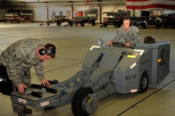 SPANGDAHLEM AIR BASE, Germany – Staff Sgt. Michael Elkington, 81st Aircraft Maintenance Unit weapons load crew chief, prepares an MJ-1 to be driven by Staff Sgt. James Clay, 81st AMU weapons load crew member, during a load crew of the quarter competition in Hangar 1 here Jan. 13. This 81st AMU team competed against a weapons load crew from the 480th AMU and won the competition. The crew will compete in the 2011 Load Crew of the Year competition against the winners from the previous quarterly competitions. The competitions are held to showcase the teamwork and capabilities of the weapons load crews during wartime, TDYs and deployments. (U.S. Air Force photo/Airman 1st Class Matthew B. Fredericks)
