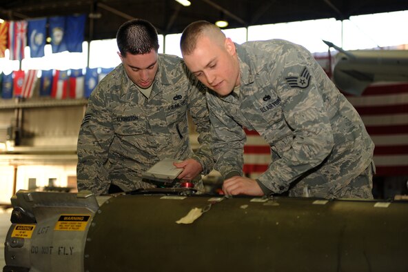 SPANGDAHLEM AIR BASE, Germany – Staff Sgt. Michael Elkington, 81st Aircraft Maintenance Unit weapons load crew chief, reads through a checklist while Staff Sgt. James Clay, 81st AMU weapons load crew member, inspects a CBU-103 bomb to be loaded onto an A-10 Thunderbolt II during a load crew of the quarter competition in Hangar 1 here Jan. 13. This 81st AMU crew competed against a weapons load crew from the 480th AMU and won the competition. The crew will compete in the 2011 Load Crew of the Year competition against the winners from the previous quarterly competitions. The competitions are held to showcase the teamwork and capabilities of the weapons load crews during wartime, TDYs and deployments. (U.S. Air Force photo/Airman 1st Class Matthew B. Fredericks)