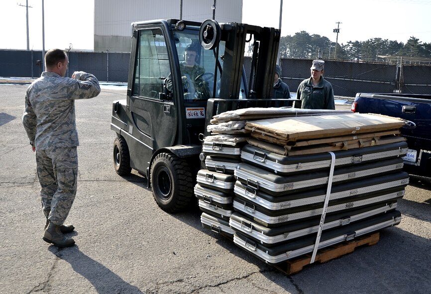 Master Sgt. Shane Dalkey, 8th Logistics Readiness Squadron personal property and passenger travel section chief, directs Airman 1st Class Kevin Brumbaugh, 8th LRS traffic management journeyman, as he maneuvers a pallet of equipment ready for shipment to the Defense Reutilization and Marketing Office at Kunsan Air Base, Republic of Korea, Jan. 10, 2012. The traffic management flight has three distinct sections that routinely perform above and beyond, putting bread and bullets in the hands of the Wolf Pack. (U.S. Air Force photo by Senior Airman Benjamin Stratton/Released