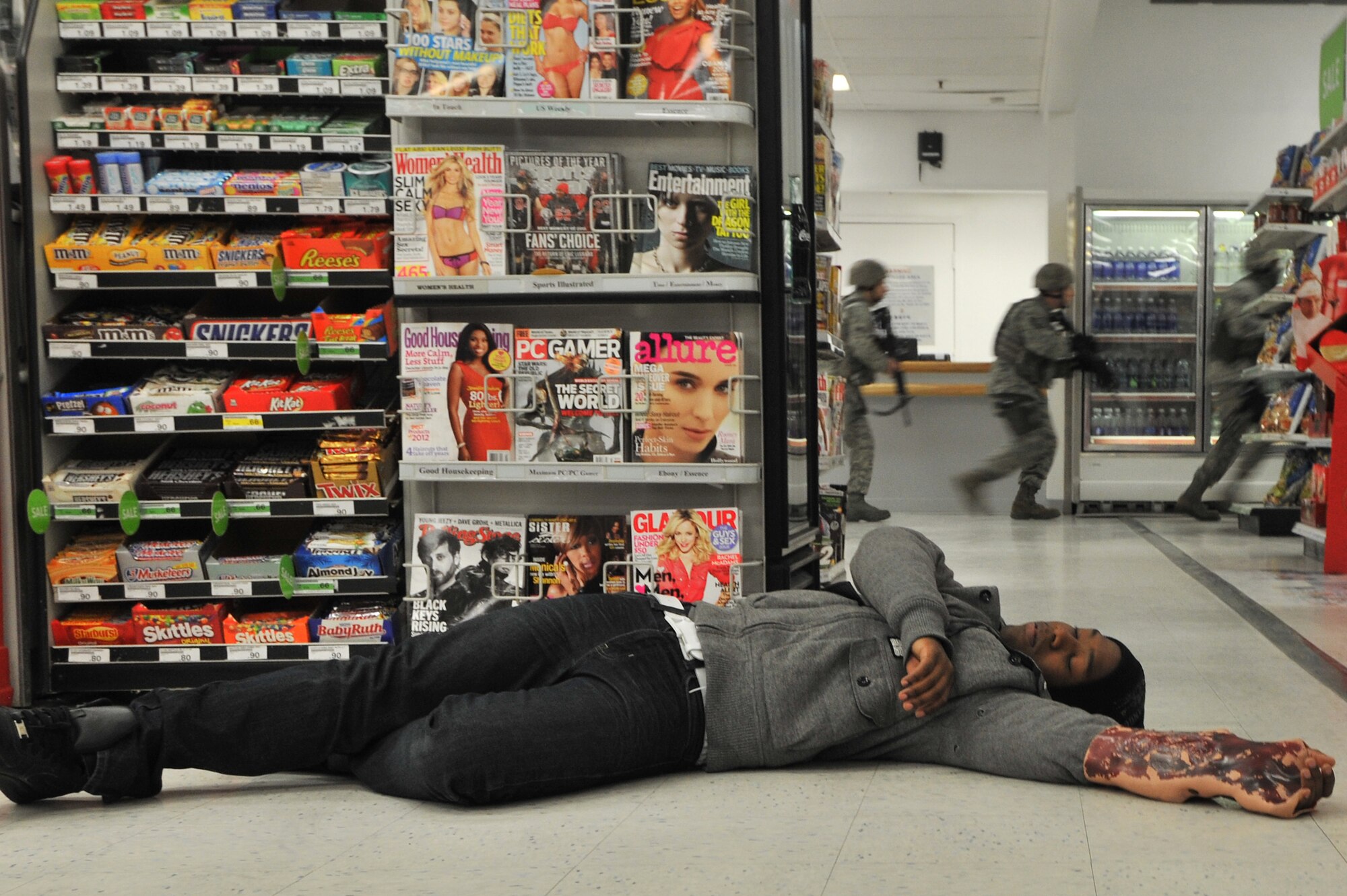 A simulated casualty lies on the floor as members of the 8th Security Forces Squadron respond to an active shooter scenario during a Pacific Air Forces High Risk Response Training at Kunsan Air Base, Republic of Korea, Jan. 13, 2012. The course is designed to help PACAF prepare to meet dangerous and unpredictable situations on military installations that require immediate law enforcement action. (U.S. Air Force photo by Senior Airman Brittany Y. Auld/Released)