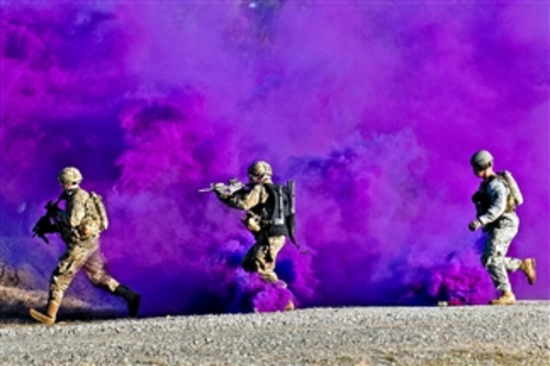 Two paratroopers and a trainer run through a smokescreen during a live-fire exercise at the Joint Readiness Training Center at Fort Polk, La., on Jan. 14, 2012.  
