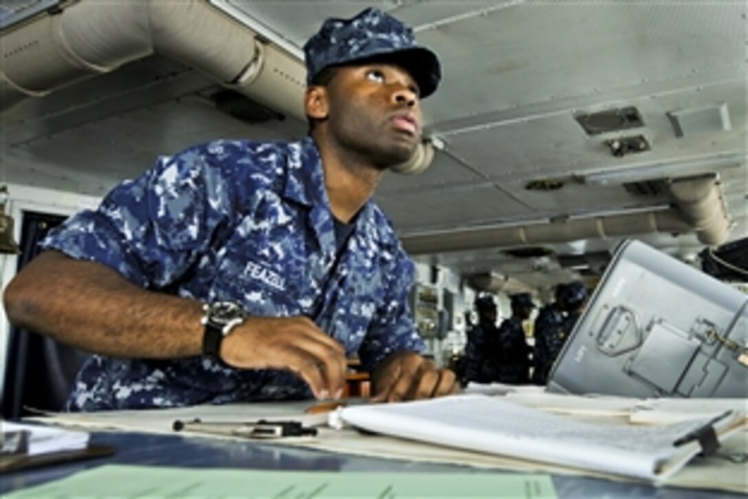 U.S. Navy Seaman Roosevelt Feazell charts a course from the bridge of the aircraft carrier USS Abraham Lincoln in the U.S. 7th Fleet area of responsibility as part of a deployment to the western Pacific and Indian Ocean. The carrier is en route to support coalition efforts in the U.S. 5th Fleet area of responsibility.