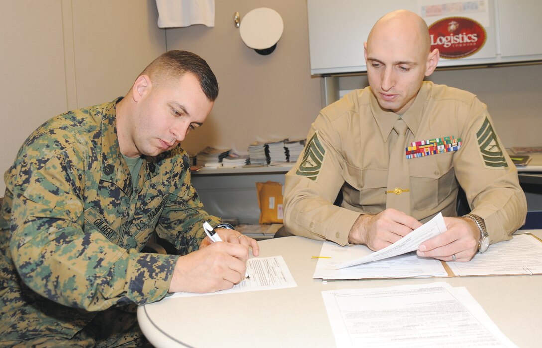 Master Sgt. Jason Spangenberg (right), career planner, Marine Corps Logistics Command, assists Gunnery Sgt. Gary Gilbert, band master, Albany Marine Band, with his re-enlistment, recently.