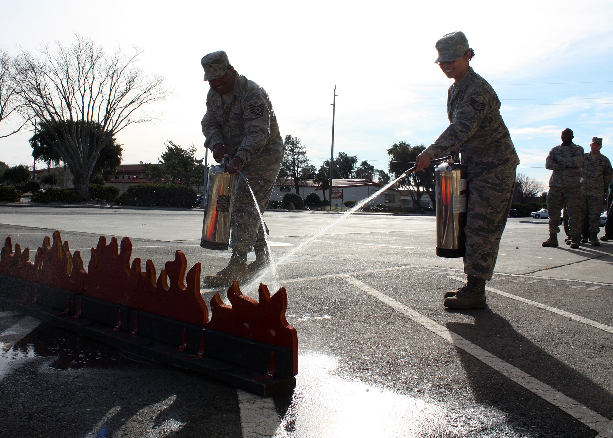 TRAVIS AIR FORCE BASE, Calif. – Airmen from the 23rd Combat Communications Squadron practice using a water-based fire extinguisher during training provided by the 349th Civil Engineer Squadron here Jan. 9. Following a computer-based training module, Airmen attend a class where they get hands-on practice identifying and using fire extinguishers. (U.S. Air Force photo/Tech. Sgt. Rachel Martinez)