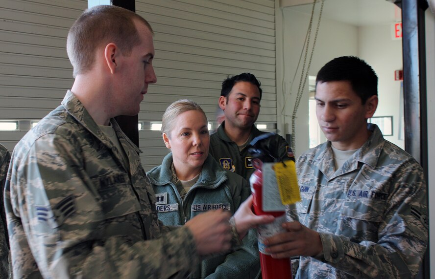 TRAVIS AIR FORCE BASE, Calif. -- Senior Airman Mark Nylander, 349th Civil Engineer Squadron firefighter, quizzes Airmen from the 23rd Combat Communications Squadron and 349th Aeromedical Evacuation Squadron on fire extinguisher inspections during training here Jan. 8. Fire extinguisher training is an annual requirement for Airmen. (U.S. Air Force photo/Tech. Sgt. Rachel Martinez