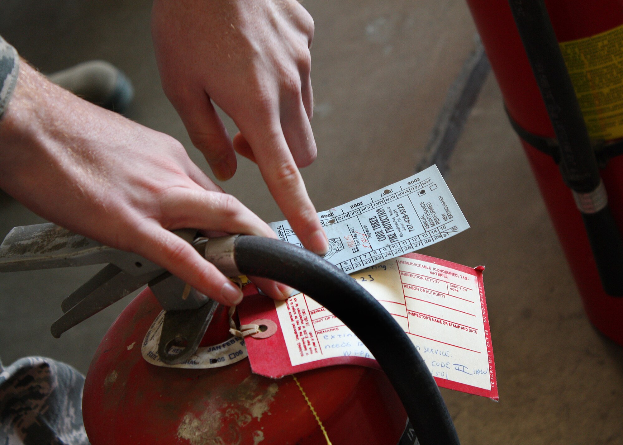 TRAVIS AIR FORCE BASE, Calif. -- Senior Airman Mark Nylander, 349th Civil Engineer Squadron firefighter, points out what to look for when inspecting a fire extinguisher during training here Jan. 8. The fire extinguisher training covered how to inspect and use the different types of fire extinguishers. (U.S. Air Force photo/Tech. Sgt. Rachel Martinez)