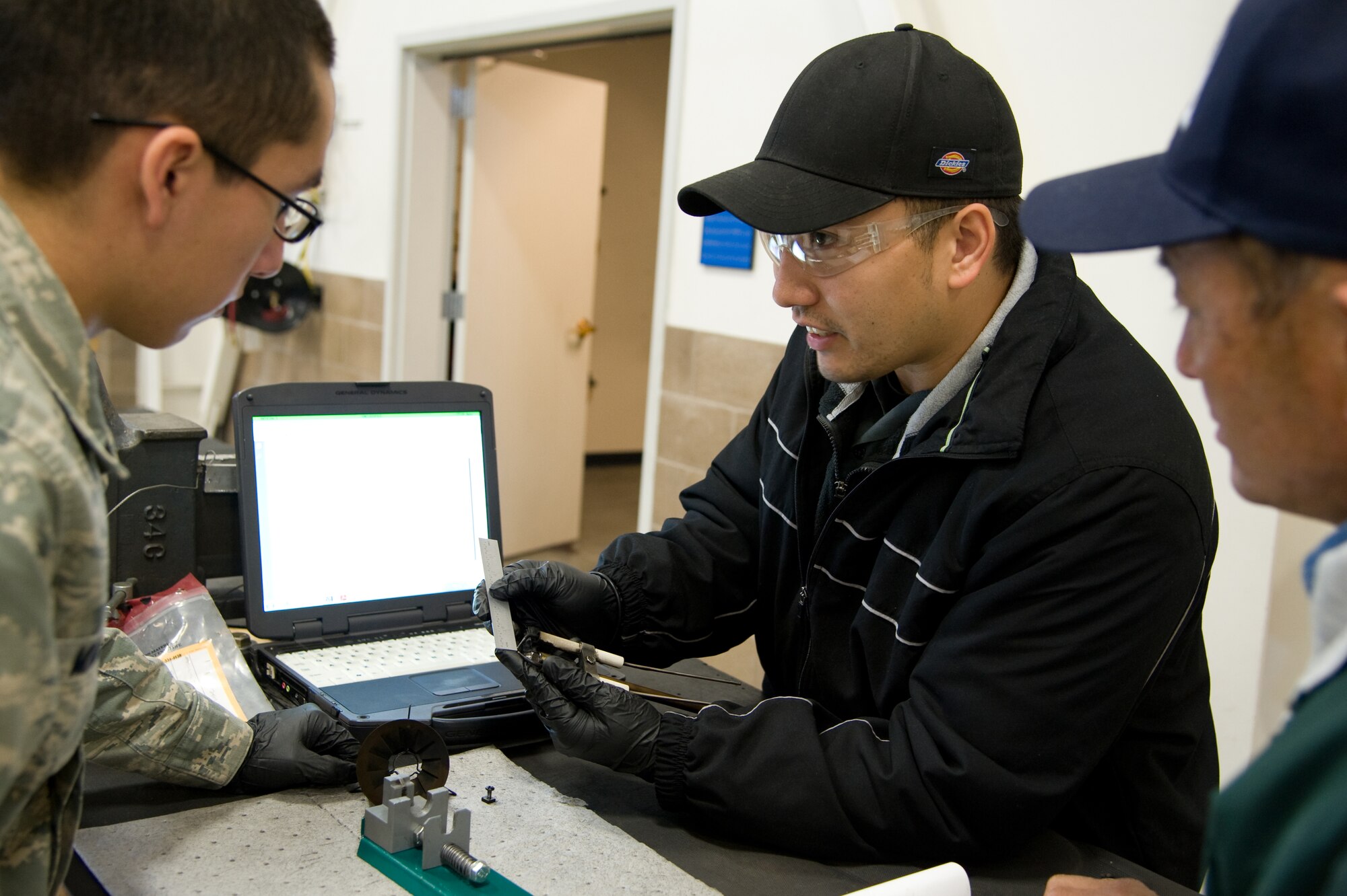 Shannon Thornley, a Air Reserve Technician, shows Airman Orlando Macin, 349 MXS seasonal training program student, exactly what the ignition gap caliper was measuring on the igniter for a new generation heater, Travis Air Force Base, Calif., January 17, 2012. (U.S. Air Force photo/Airman 1st Class Nicole Leidholm)