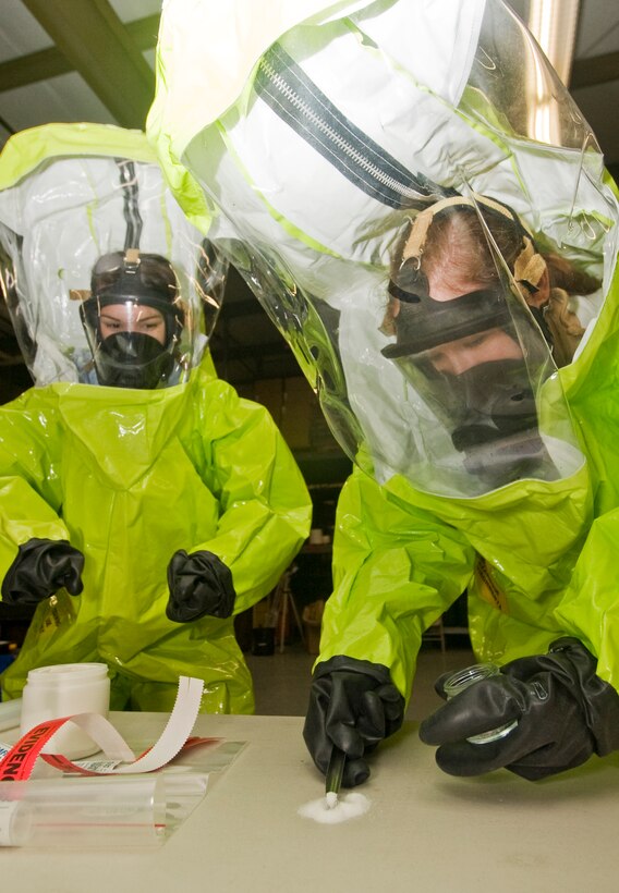 Senior Airman Rosalyn Knaust, left, 11th Civil Engineer Squadron emergency management apprentice, observes as Airman 1st Class Molly Clune, 11 CES emergency management apprentice, collects a sample of simulated suspicious powder during crime scene preservation training at the 11 CES Readiness Emergency Management Flight facility Jan. 12.  (Photo /Bobby Jones)