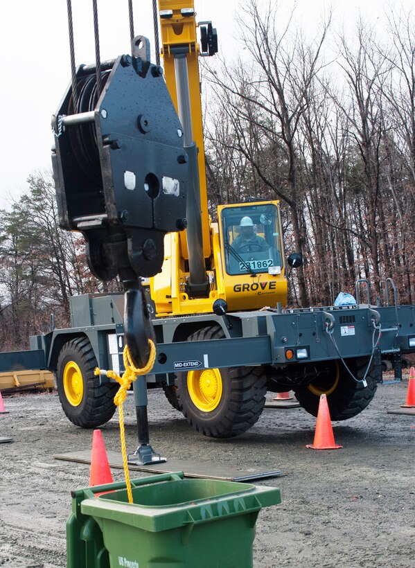 Staff Sgt. Jerime Garvin, 11th Civil Engineer Squadron heavy equipment craftsman, maneuvers a rope attached to a crane hook into a recycle bin as part of pendulum boom angle training at the snow barn Jan. 12. (Photo /Bobby Jones)