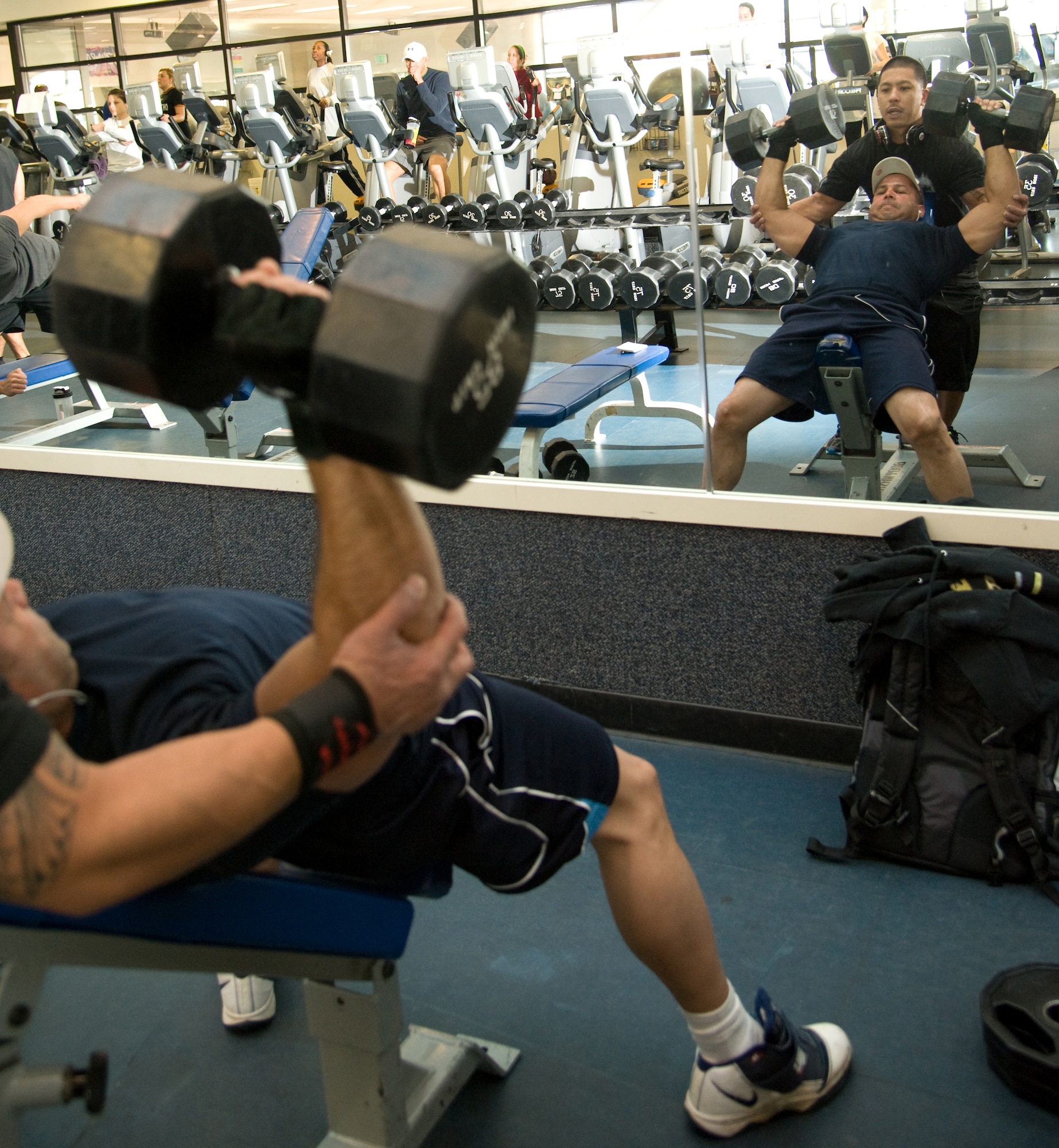 Mario Rios, retired security forces Airman, lifts weights as Ray Omoso, reservist 349 MXS, helps him keep his form at the Travis Fitness Center, Calif., January 17. (U.S. Air Force photo/Airman 1st Class Nicole Leidholm)