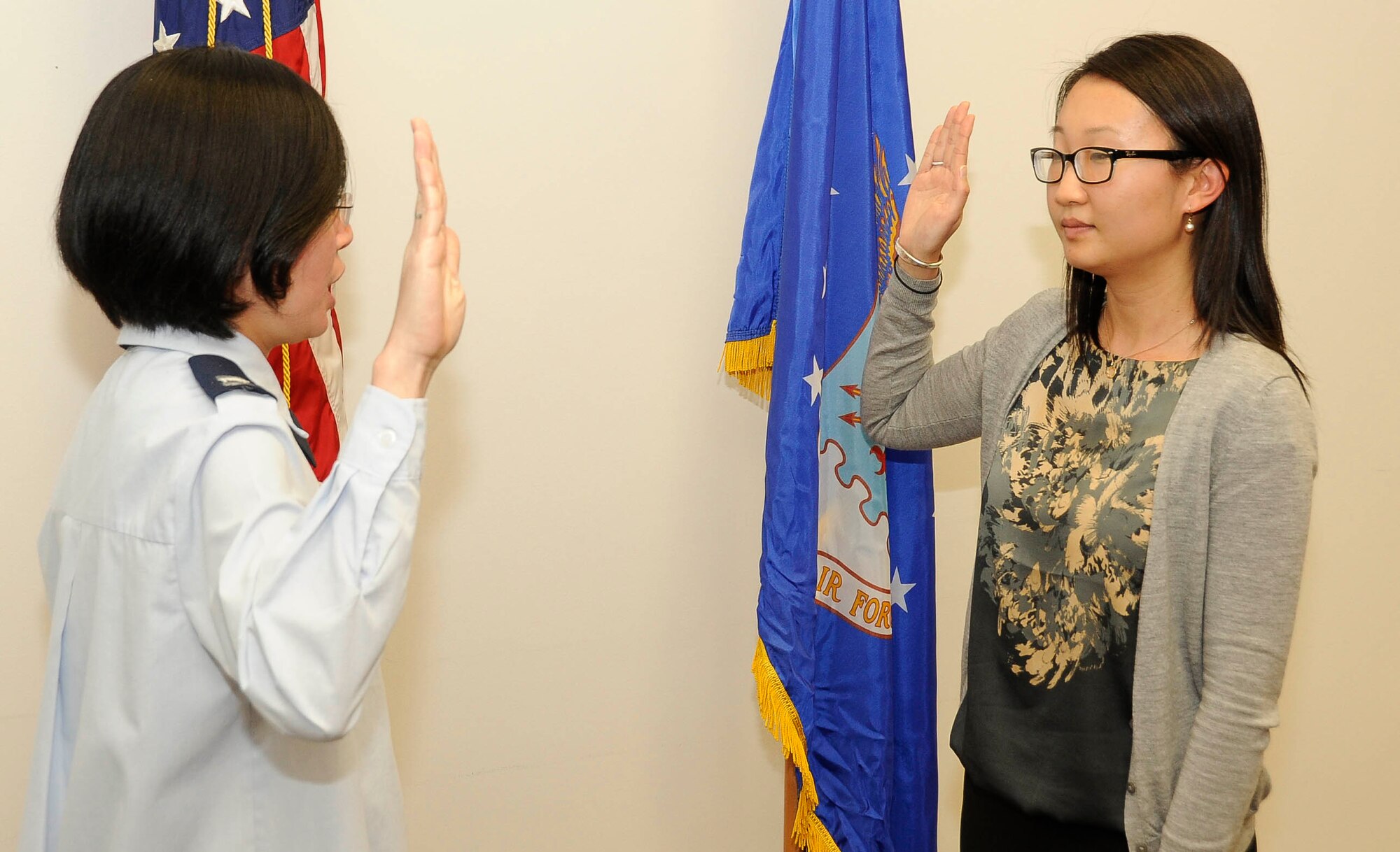 Capt. Nhon Nguyen, chief of pharmacy operations at the 87th MDG pharmacy, swears in Jennifer Wang, pharmacy intern, during a commissioning ceremony Jan. 10 at the Edwards Resource Center here. Wang received a scholarship from the Health Professions Scholarship Program. She is commissioned as a second lieutenant, but will not serve on active duty until she graduates from the Ernest Mario School of Pharmacy at Rutgers University, Newark, N.J. in May. (U.S Air Force photo by Airman Ryan Throneberry/Released)