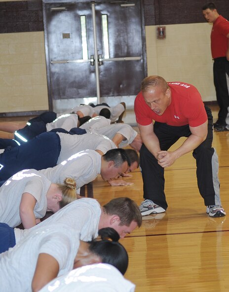 Mike Unden motivates Airmen during the Fitness Improvement Training program in the fitness center on Seymour Johnson Air Force Base, N.C., Jan. 18, 2011. The program helped reduce the 4th Fighter Wing’s physical training test failure rate from 8.8 percent to 6.7 percent since October. Unden is a military fitness specialist with the 4th Force Support Squadron. (U.S. Air Force photo/Senior Airman Gino Reyes)