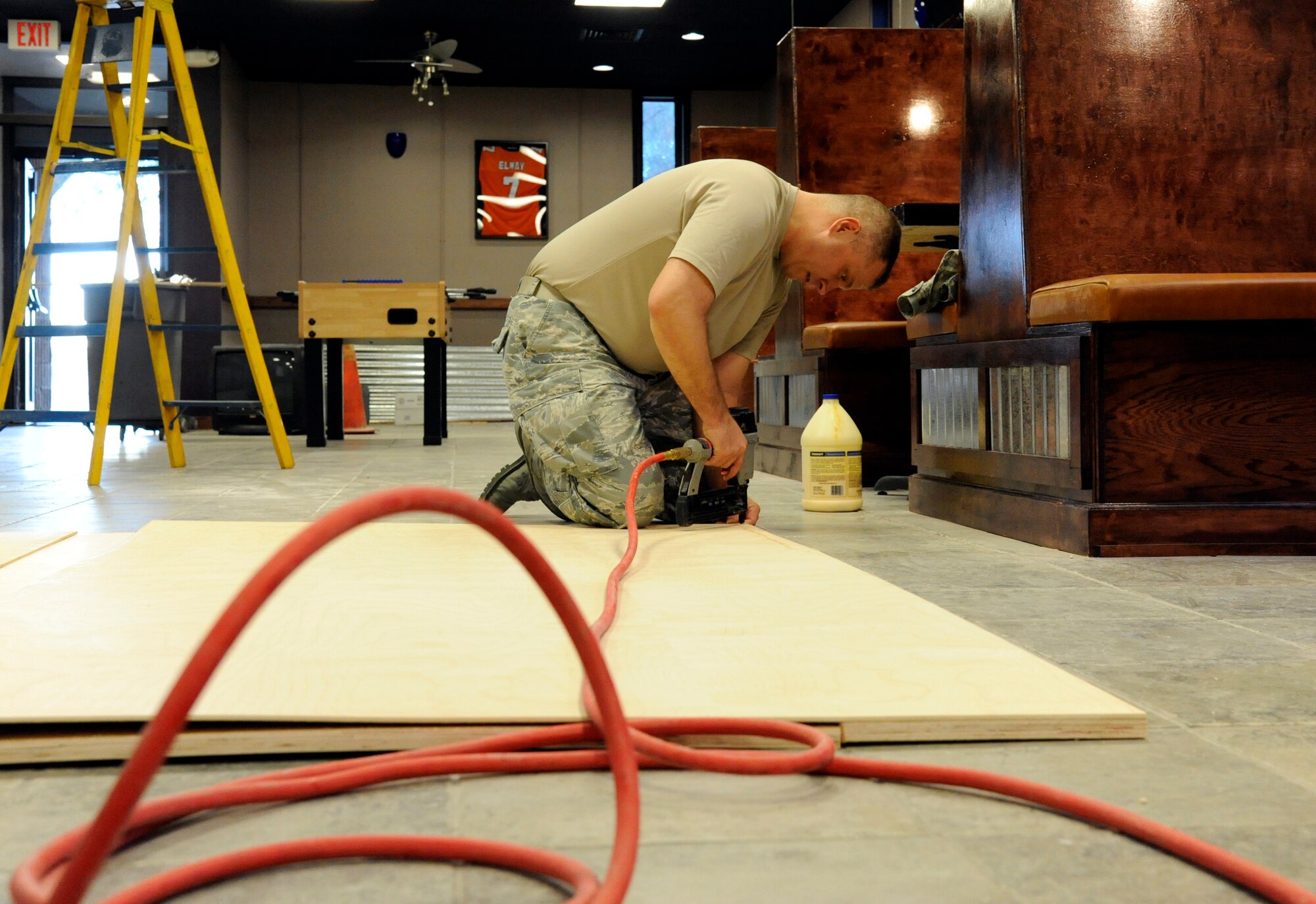LAUGHLIN AIR FORCE BASE, Texas – Master Sgt. Lyman Howard, 47th Force Support Squadron base training manager, uses a nail gun to reinforce the back of a display recently glued together at the Stripes enlisted club here Jan. 17. More than 90 volunteers have contributed 2,400 man hours in the creation of the new enlisted club. (U.S. Air Force photo/Airman 1st Class Nathan L. Maysonet)